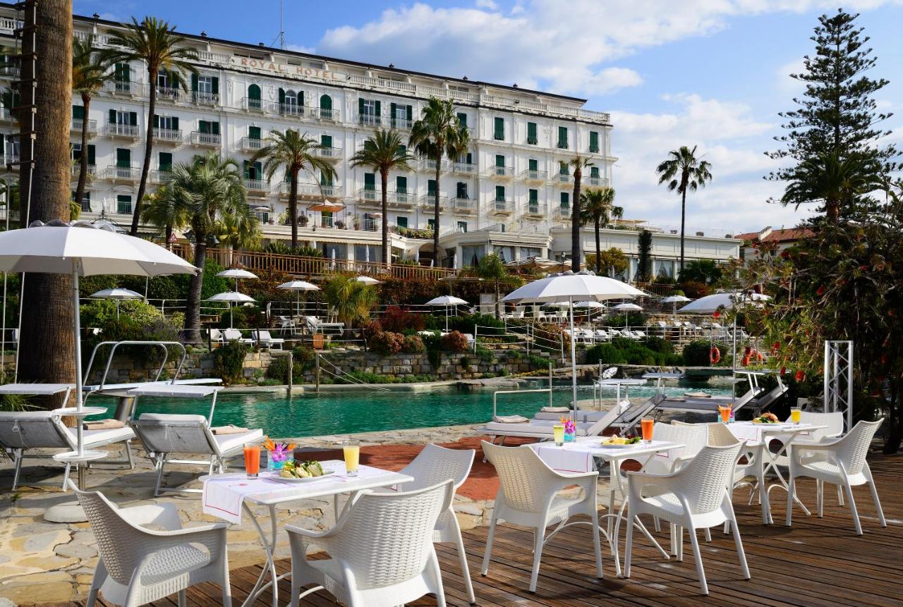 een hotel met tafels en stoelen naast een zwembad bij Royal Hotel Sanremo in Sanremo