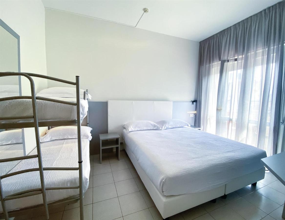 een slaapkamer met twee stapelbedden en een raam bij Hotel Aron Rimini in Rimini