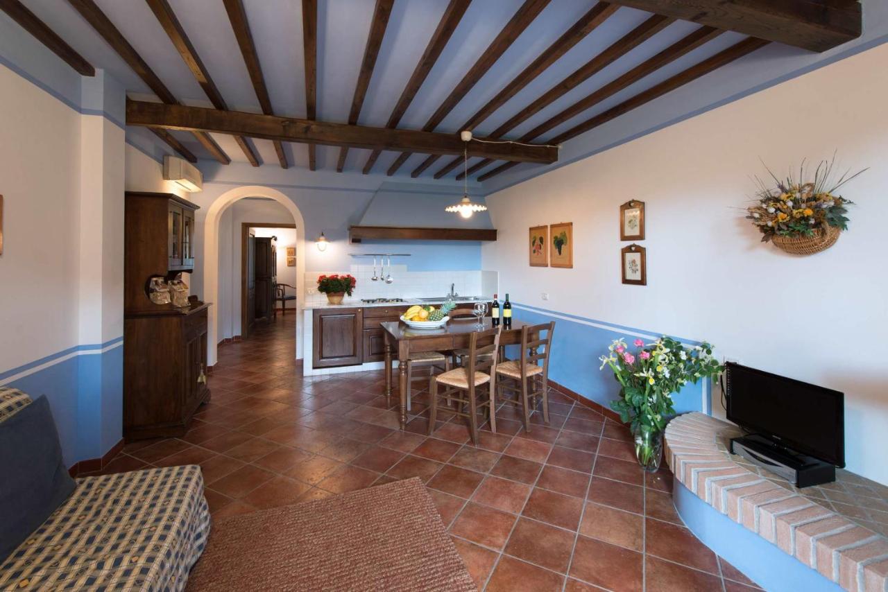 een woonkamer met een tafel en een keuken bij Casa Lari in San Gimignano