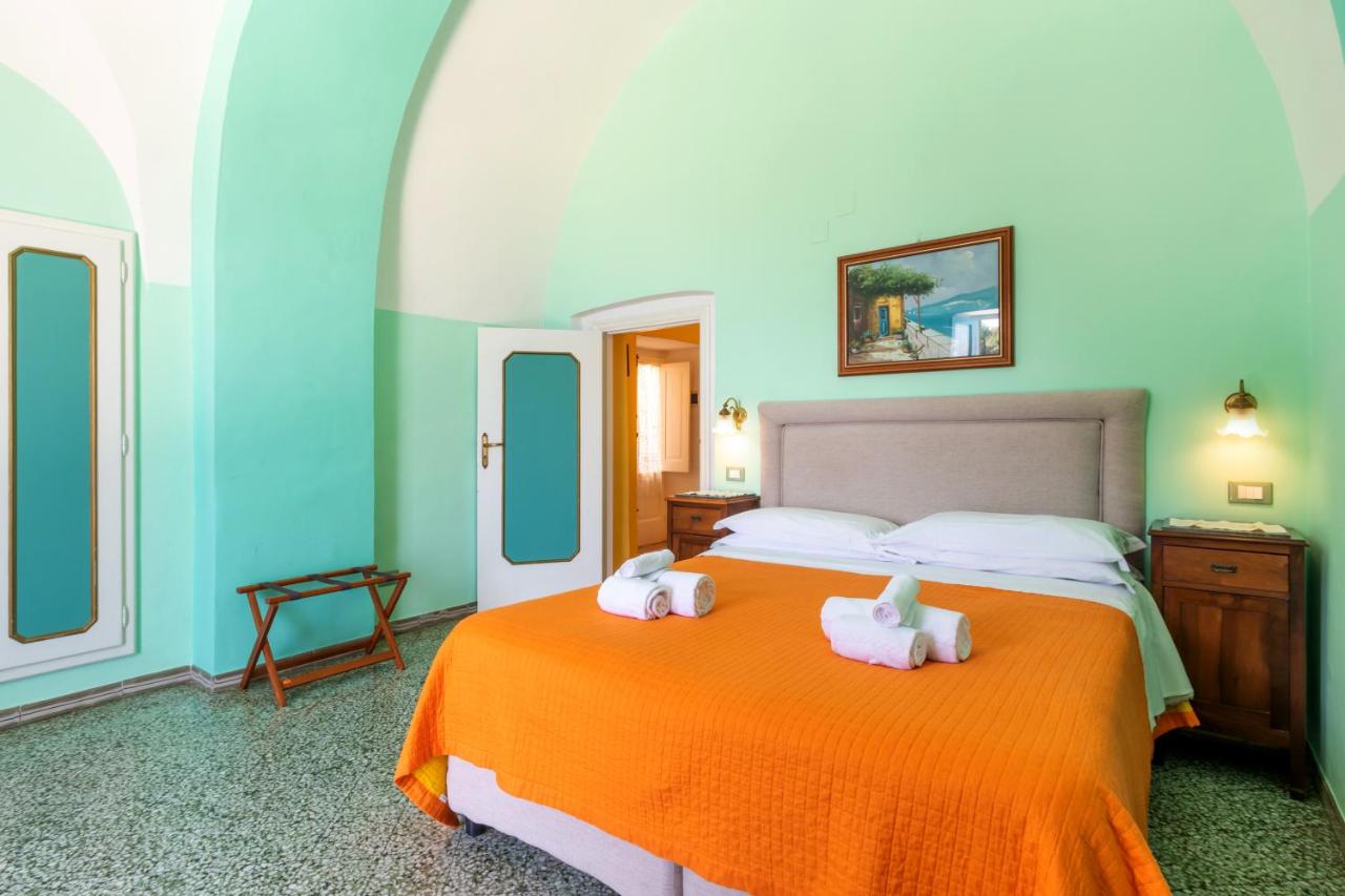 een slaapkamer met een bed waarop twee kussens liggen bij Villarena Relais in Nerano +95 foto's