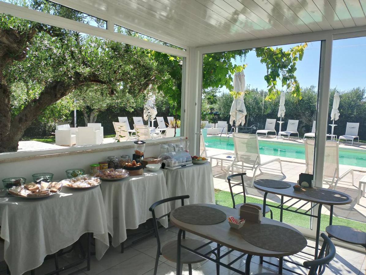 een tafel met eten erop op een terras met een zwembad bij Signorino Resort & Spa in Marsala +69 foto's