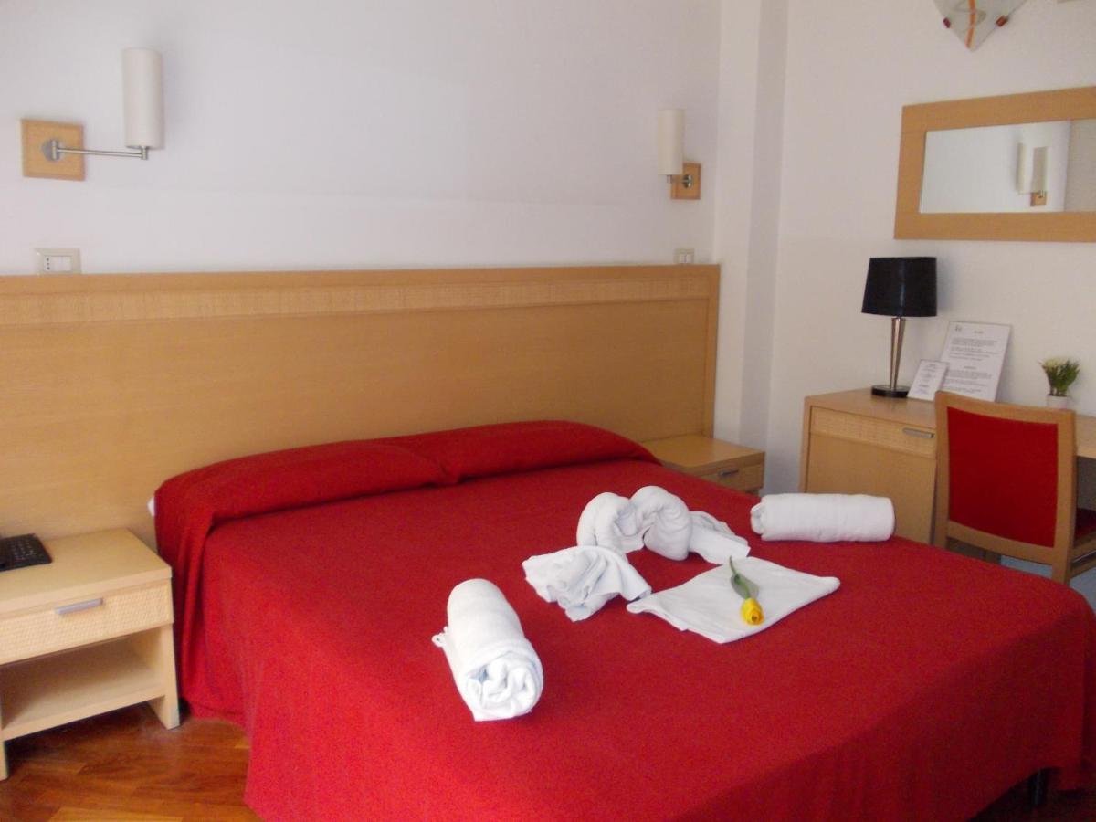 een hotelkamer met een rood bed met handdoeken erop. bij Hotel Catania Town in Catania