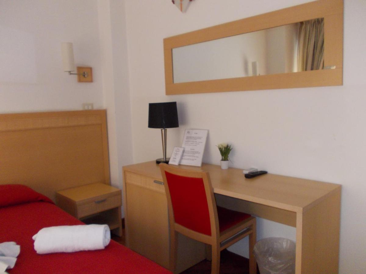 een slaapkamer met een bureau met een rode stoel en een bed bij Hotel Catania Town in Catania