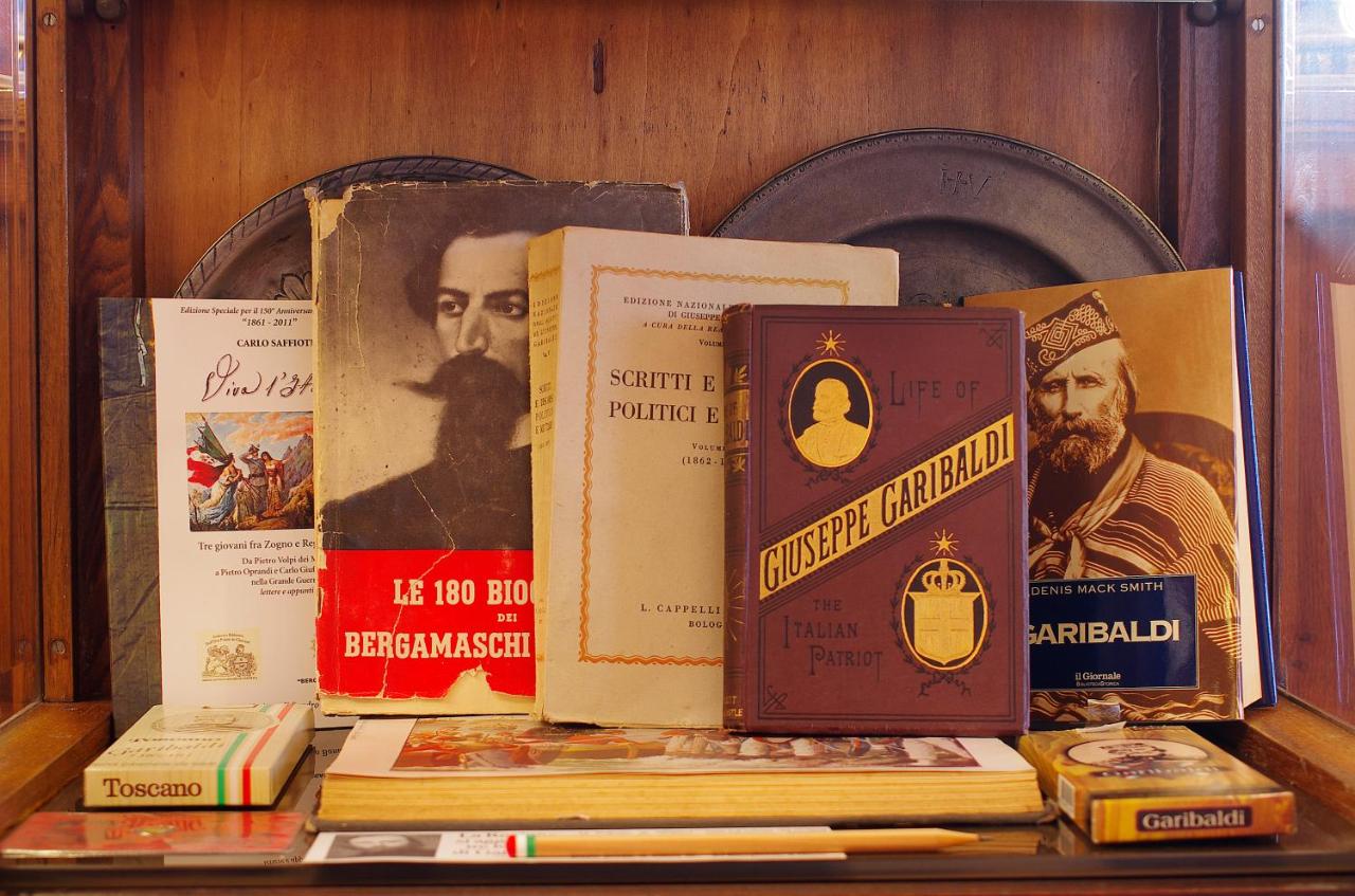 een stapel boeken die op een plank staan bij Hotel Città Dei Mille in Bergamo