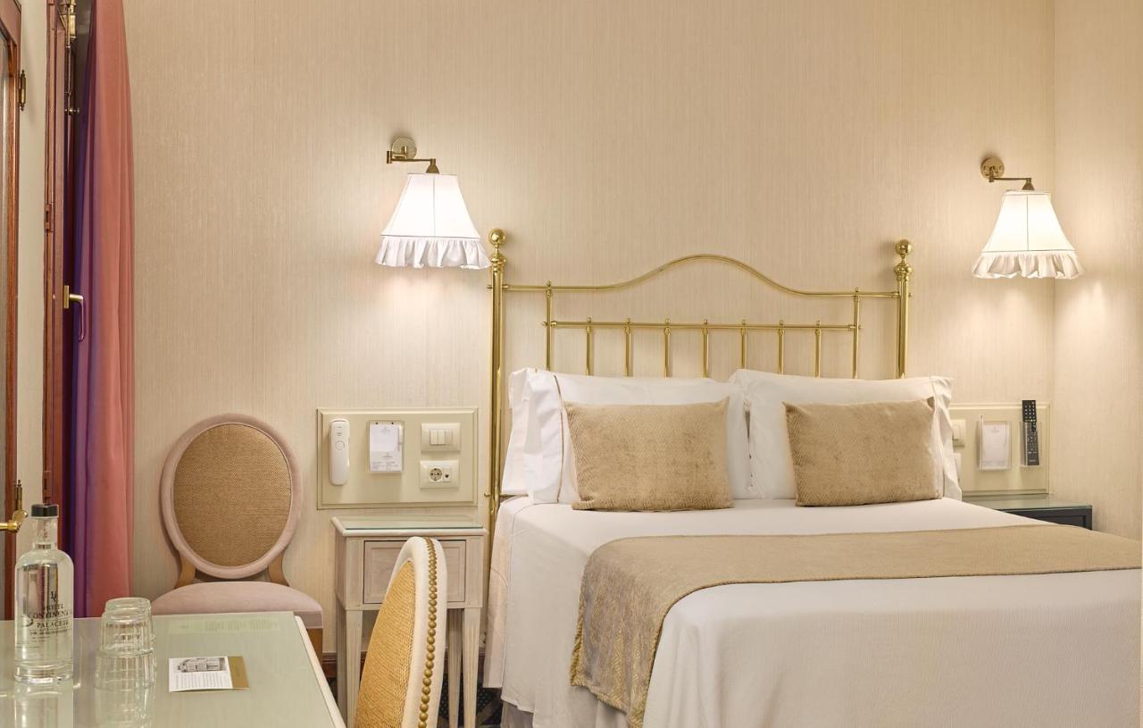 een slaapkamer met een bed, twee lampen en een tafel bij Hotel Continental Palacete in Barcelona