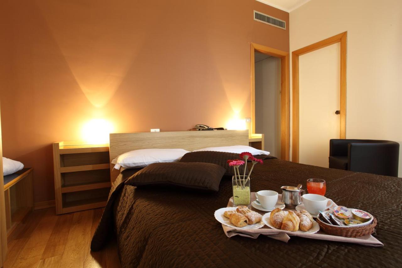 een hotelkamer met een bed waarop een dienblad met eten staat bij Hotel Del Viale in Agrigento
