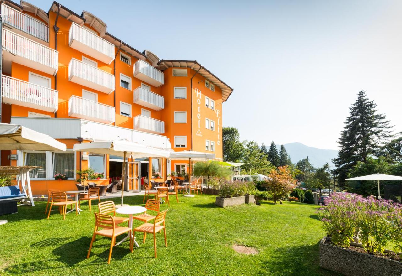 een hotel met stoelen en tafels op een binnenplaats bij Nature Bio Hotel Elite in Levico Terme