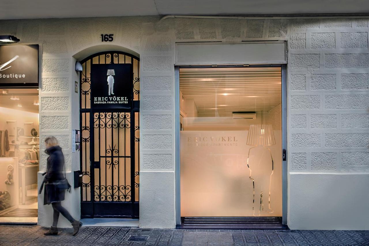 een vrouw loopt langs een winkeldeur bij Eric Vökel Boutique Apartments - Sagrada Familia Suites in Barcelona