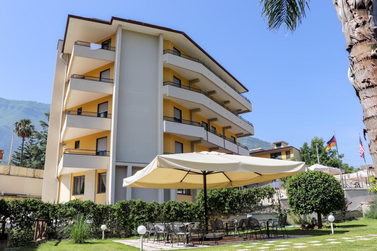 een hotel met een parasol, tafels en stoelen bij Europa Stabia Hotel in Castellammare di Stabia