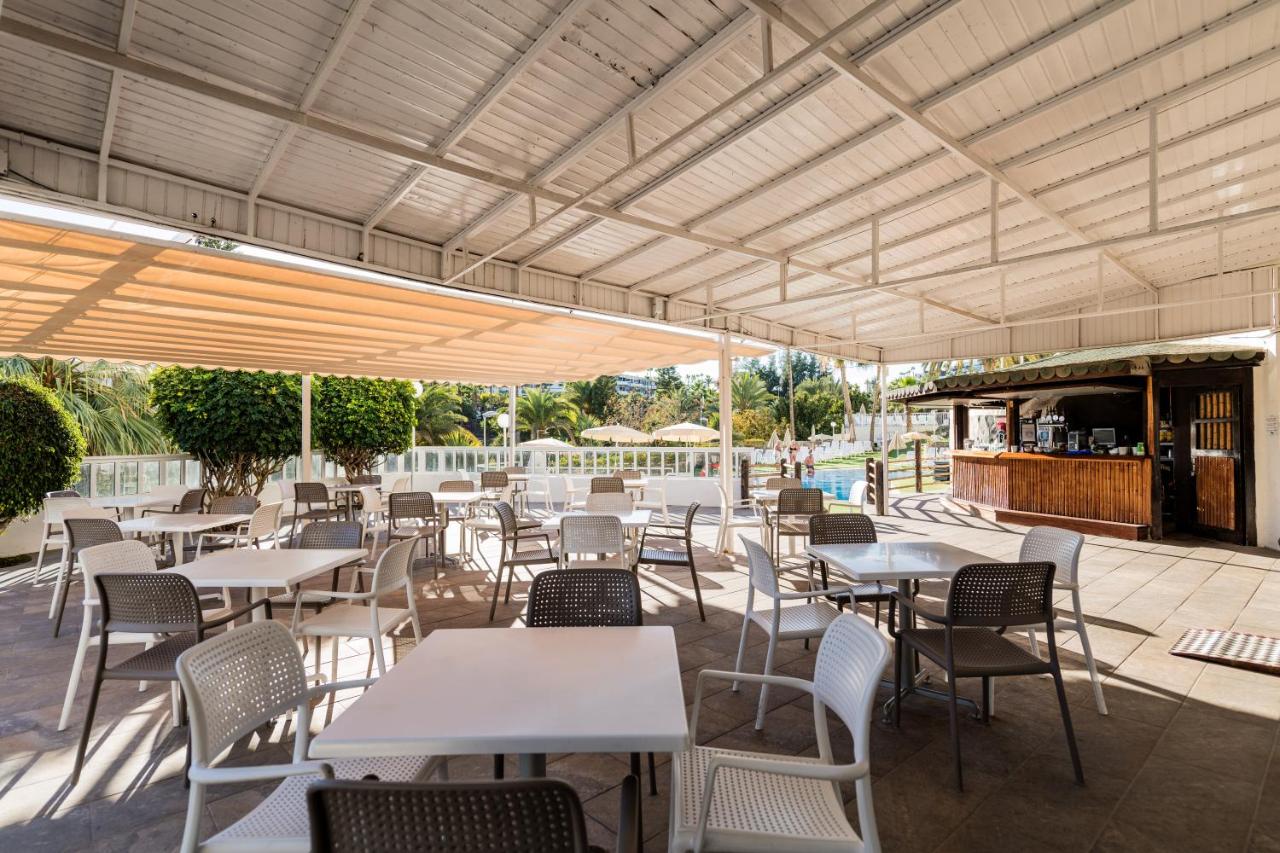 een buitenterras met tafels en stoelen en een bar bij Hotel Folias San Agustín in San Agustin