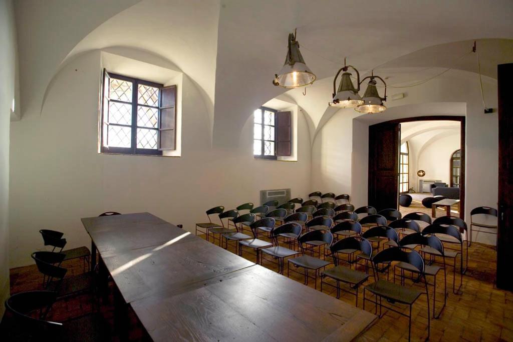 een grote kamer met een grote houten tafel en stoelen bij Foro Appio Mansio Hotel in Latina +49 foto's