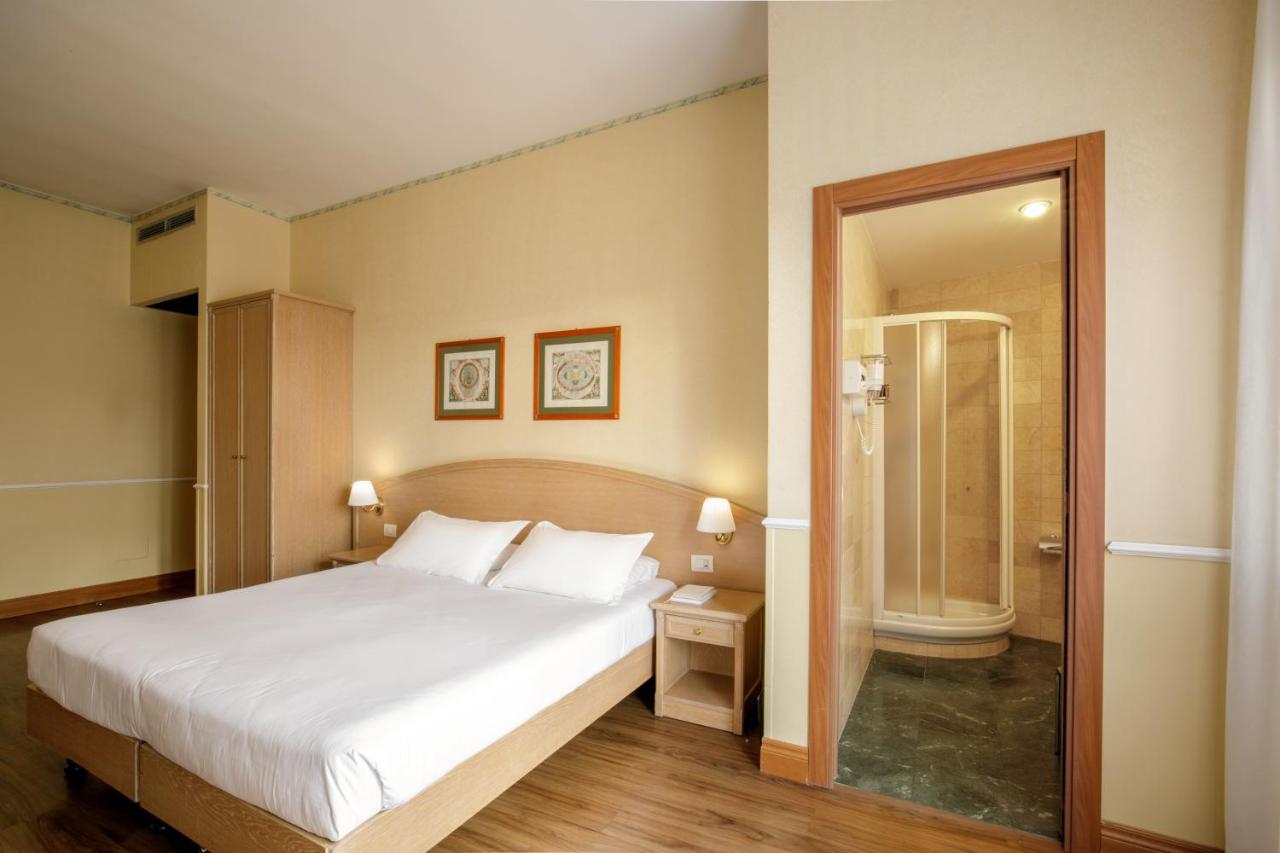 een slaapkamer met een groot wit bed en een douche bij Hotel Santa Costanza by OMNIA hotels in Rome