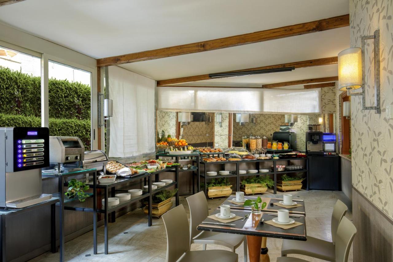 een restaurant met tafels en stoelen in een ruimte bij Hotel Santa Costanza by OMNIA hotels in Rome