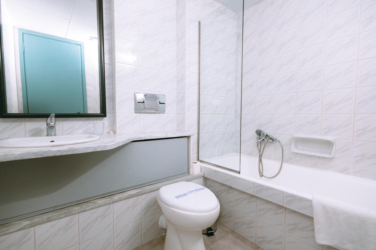 een witte badkamer met een toilet en een wastafel bij Santa Marina Unique Hotel in Agios Nikolaos