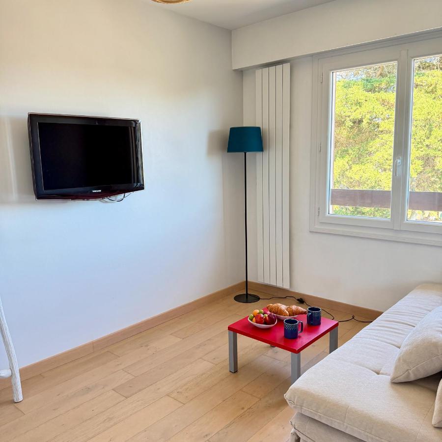 een woonkamer met een tv en een rode tafel bij rivage in Pornichet