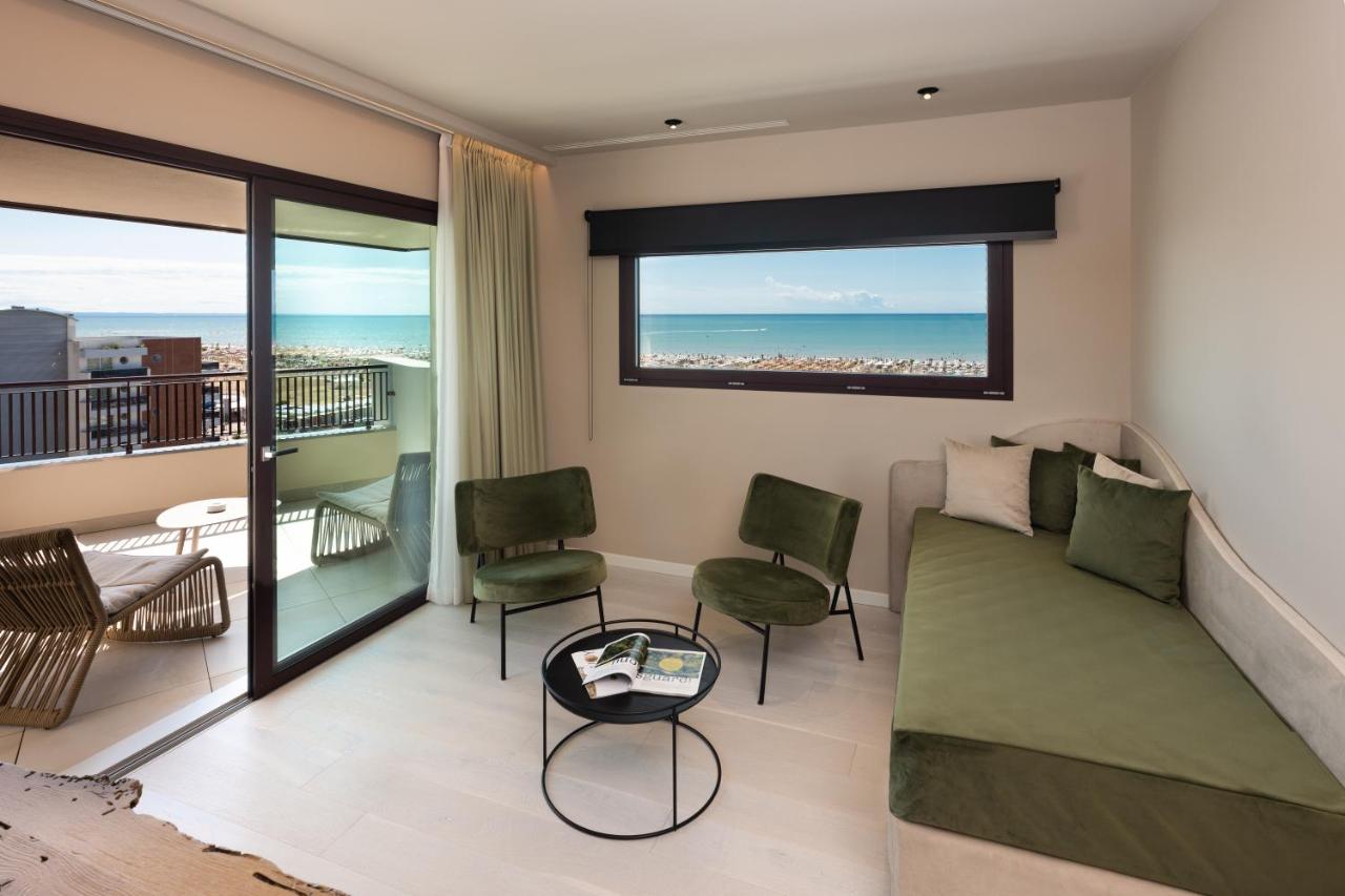 een woonkamer met een bank en een balkon bij Savoy Beach Hotel & Thermal Spa in Bibione