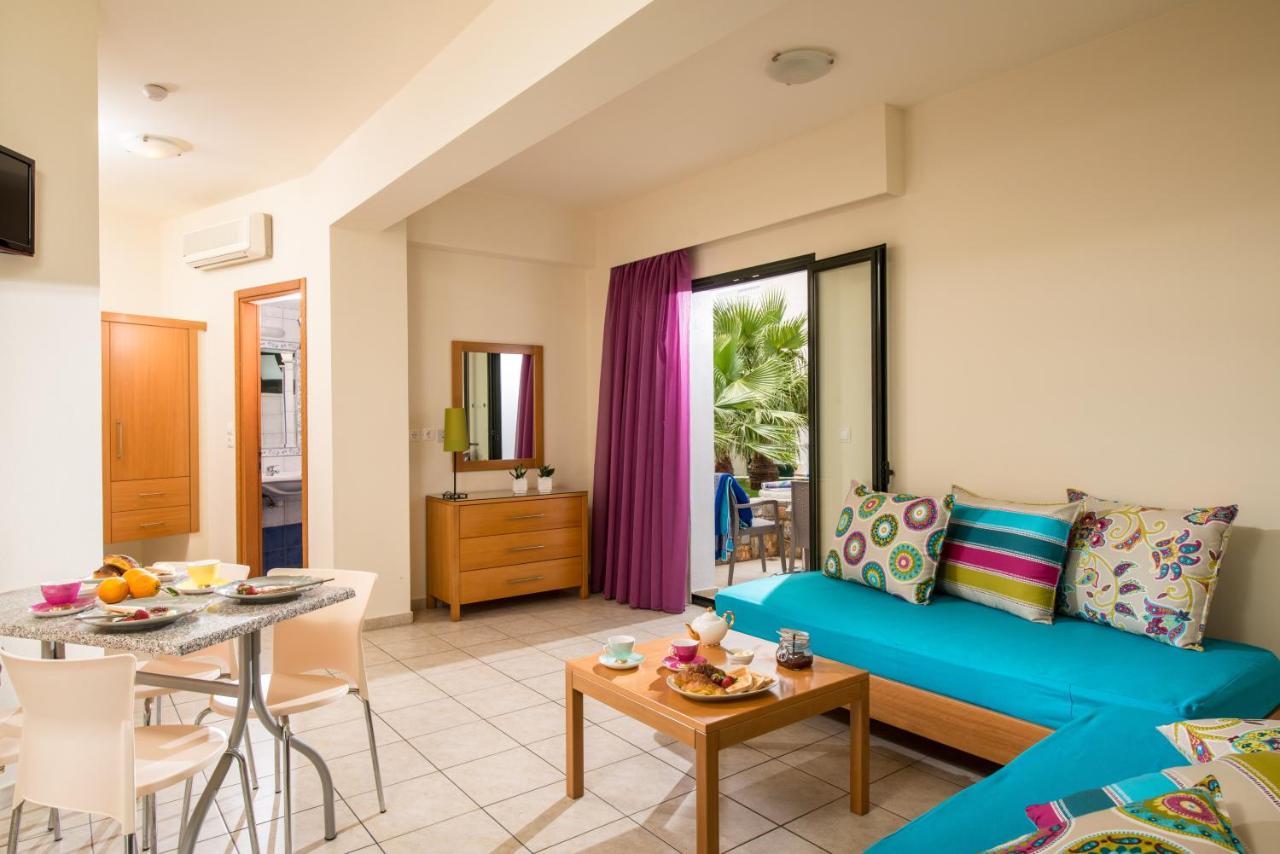 een woonkamer met een blauwe bank en een tafel bij Kristalli Hotel Apartments in Malia