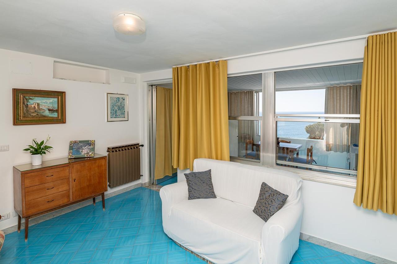 een woonkamer met een witte bank en een raam bij Casa Maresca Residence in Positano