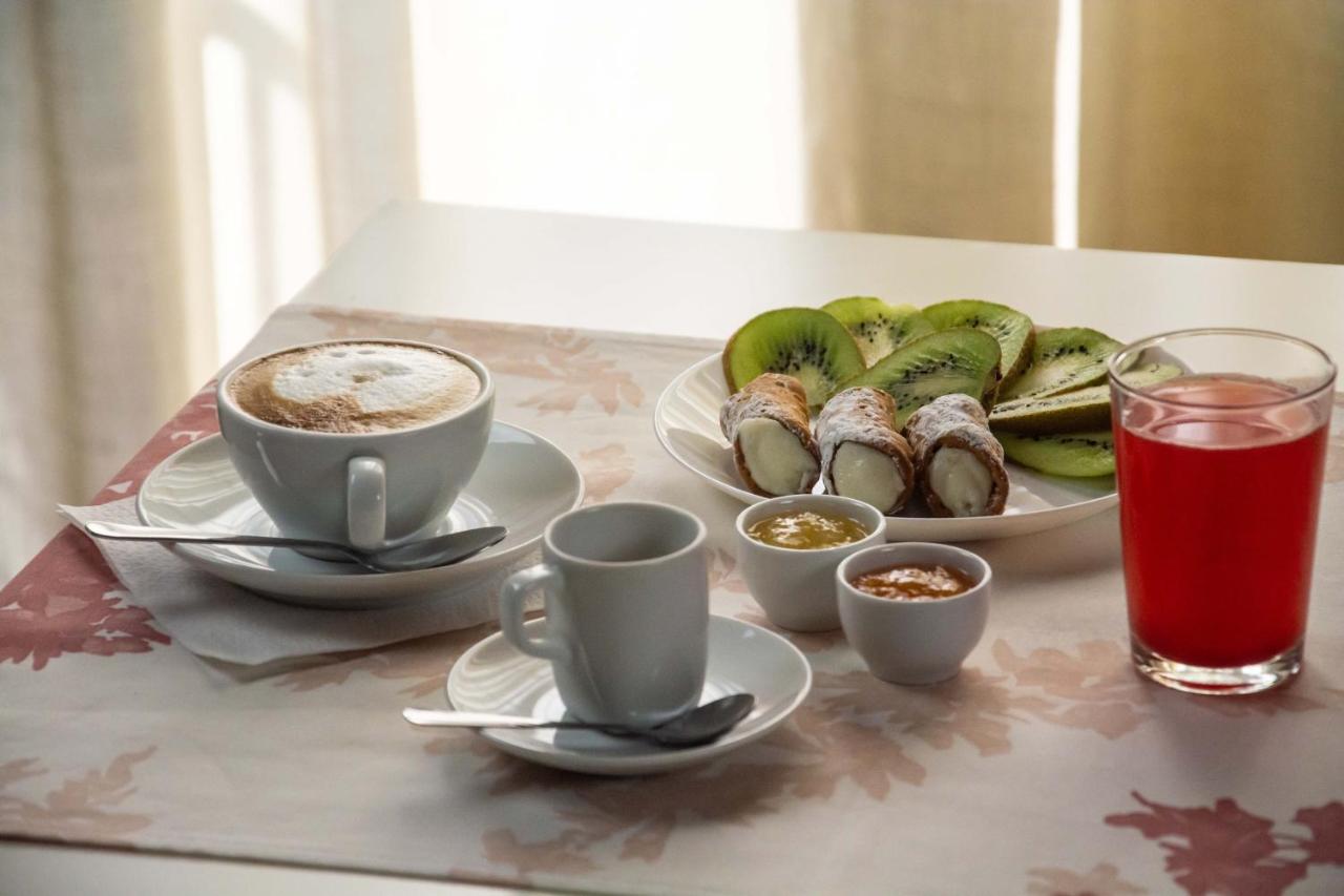 een tafel met twee kopjes koffie en borden met eten bij La Collegiata Guest House in Catania