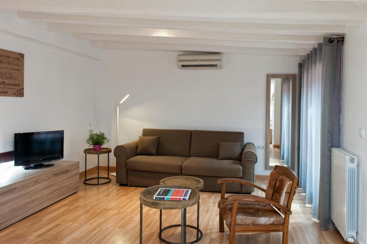 een woonkamer met een bank en een tv bij MH Apartments Liceo in Barcelona