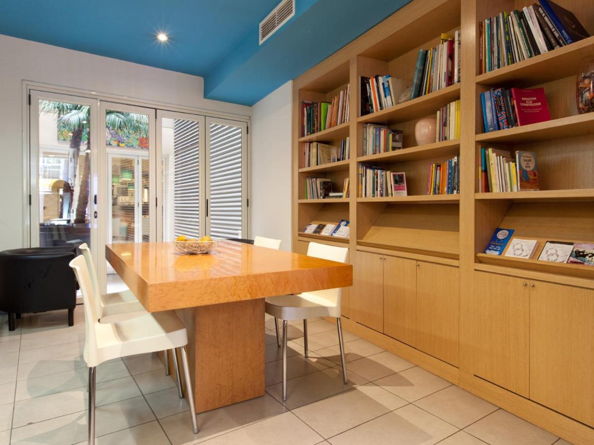 een eetkamer met een tafel en boekenkasten bij Hotel Sagrada Familia in Barcelona