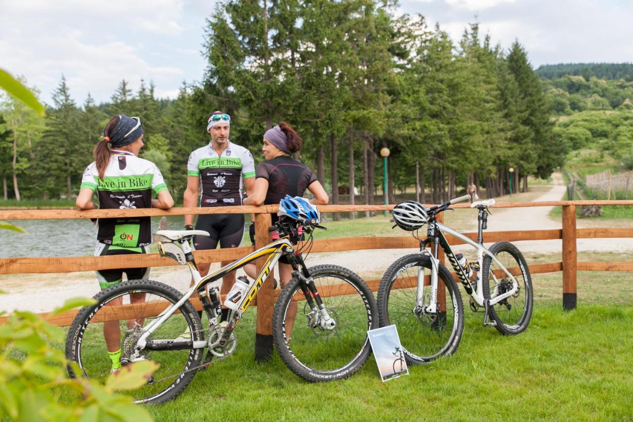 een groep mensen die met fietsen rond een bank staan bij Hotel Miramonti in Bagno di Romagna