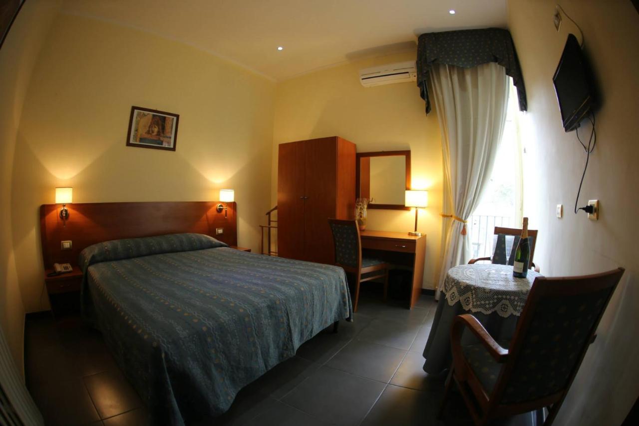 een slaapkamer met een bed, een tafel en een bureau bij Hotel Nettuno in Napels