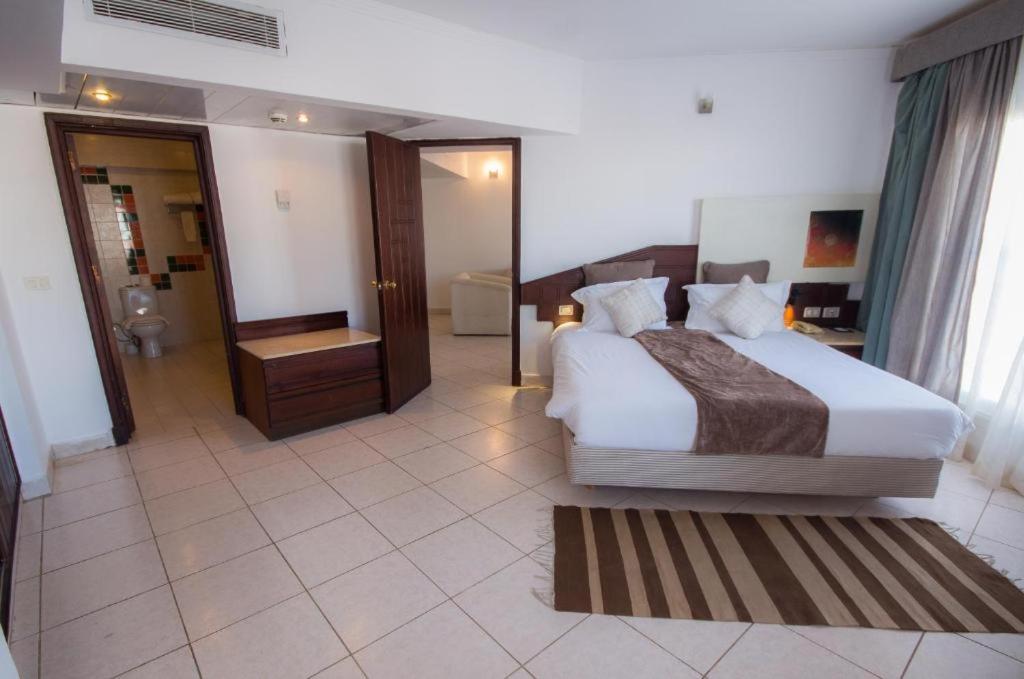 een slaapkamer met een groot bed en een badkamer bij Swiss Heaven Sharming Inn Hotel-Couples & Families only in Sharm El