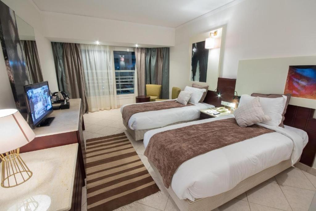 een hotelkamer met twee bedden en een televisie bij Swiss Heaven Sharming Inn Hotel-Couples & Families only in Sharm El 
