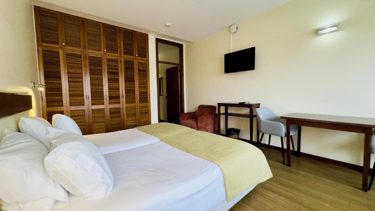 een hotelkamer met een bed, een tafel en een bureau bij Traineira Vila Ventura Village in Caniço