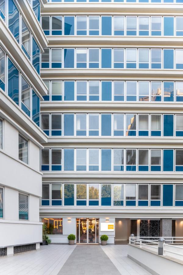 Een exterieurfoto van een gebouw met blauwe ramen. bij Aparthotel Colombo Roma in Rome