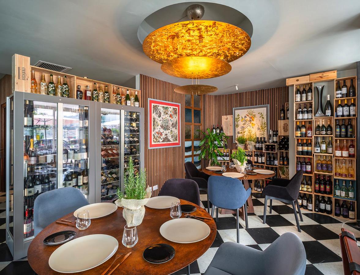 een restaurant met een tafel, stoelen en een kroonluchter bij Rosabianca Boutique Hotel in Rapallo