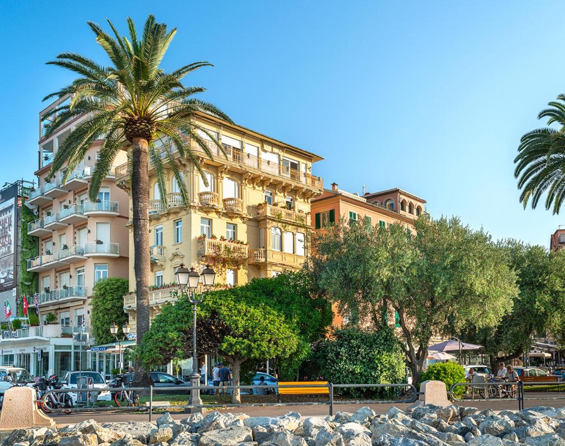 een groot gebouw met een palmboom ervoor bij Rosabianca Boutique Hotel in Rapallo