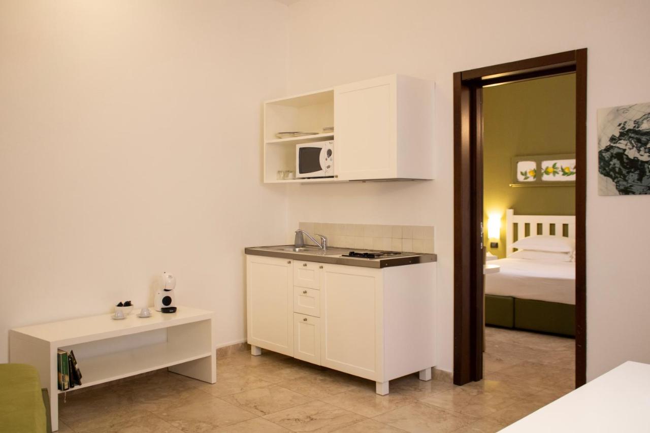 een keuken met een gootsteen en een kamer met een bed bij San Domenico Residence by BADIA NUOVA in Trapani
