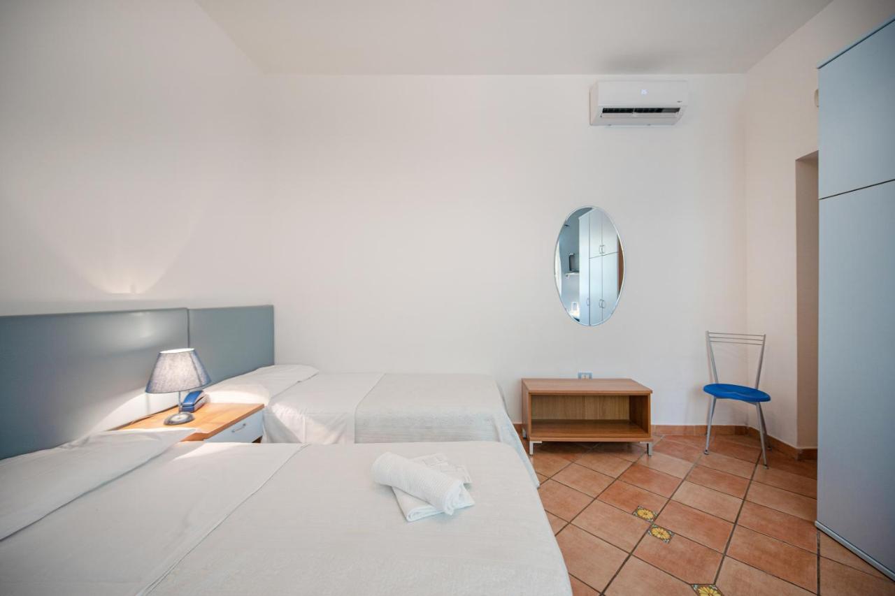 een slaapkamer met twee bedden, een tafel en een stoel bij Solcalante in Procida