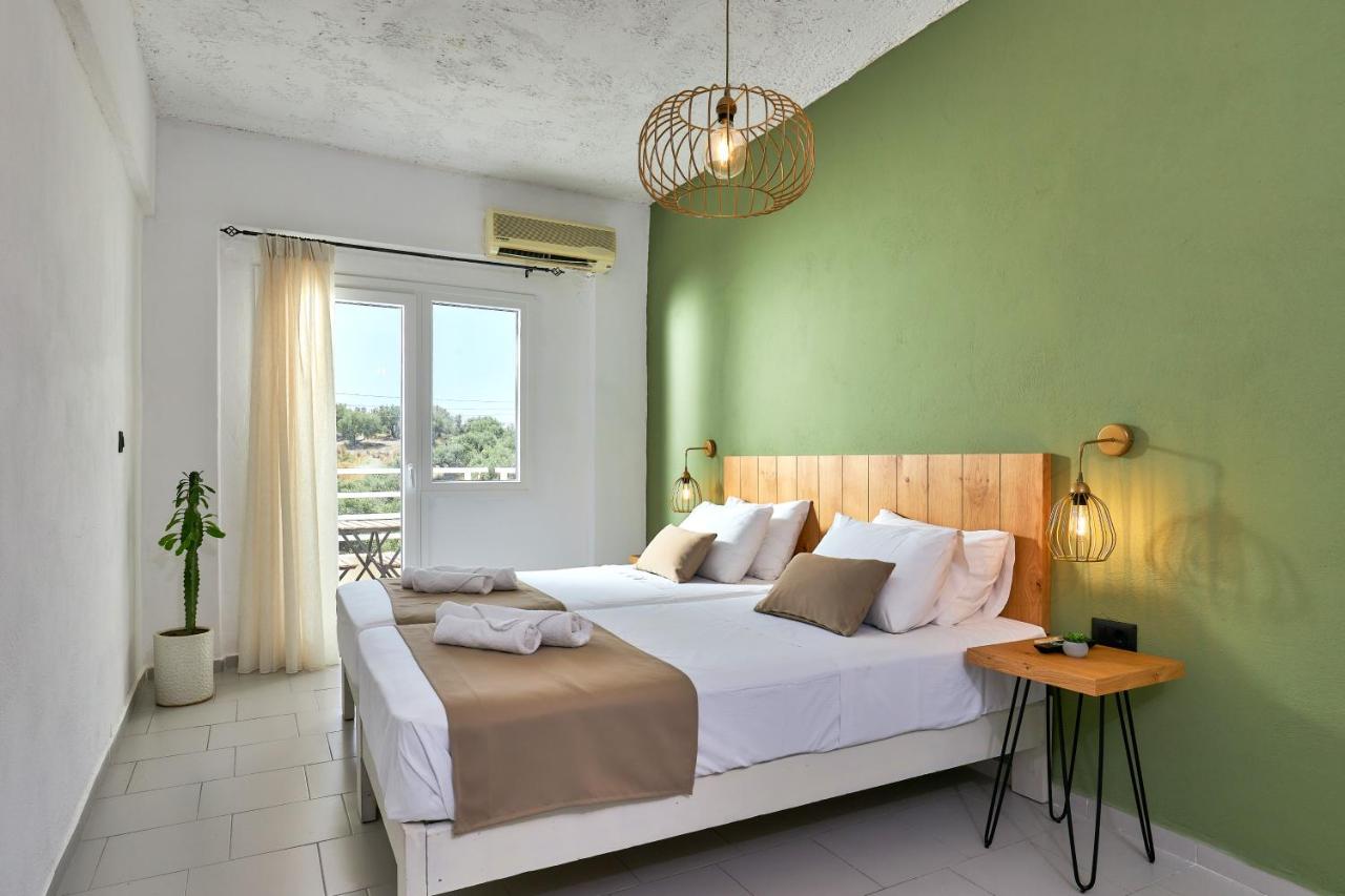 een slaapkamer met een groot bed en een groene muur bij Charm Hotel, Hersonissos in Chersonissos