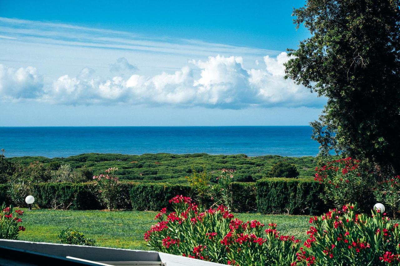 een uitzicht op de oceaan vanuit een tuin met bloemen bij Residence Solemaremma in Castiglione della Pescaia