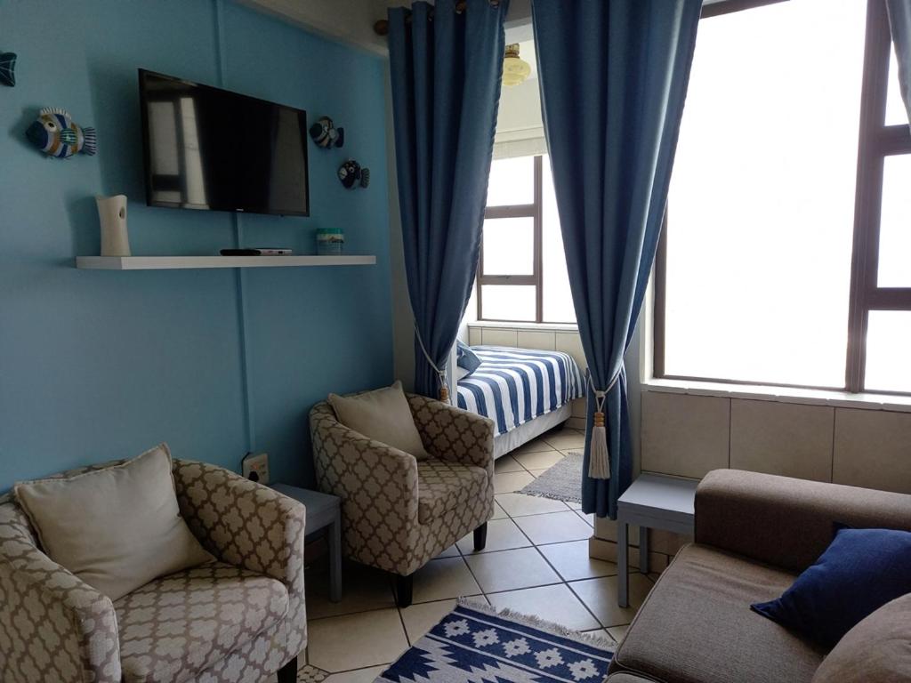 een woonkamer met twee stoelen en een tv bij South Coast Riviera - 805 in Port Shepstone