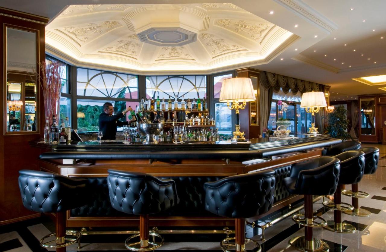 een bar in een hotel met iemand die achter de bar staat bij Hotel Splendid in Baveno