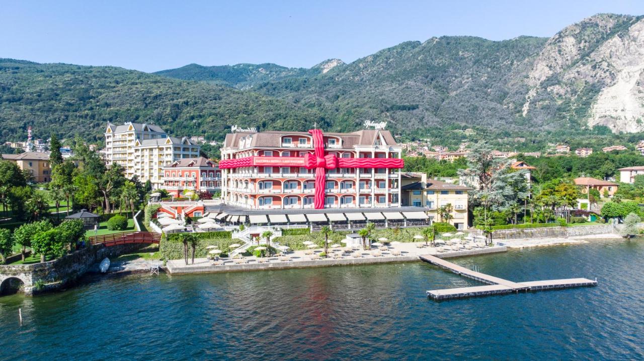 een groot rood gebouw midden in een wateroppervlak bij Hotel Splendid in Baveno