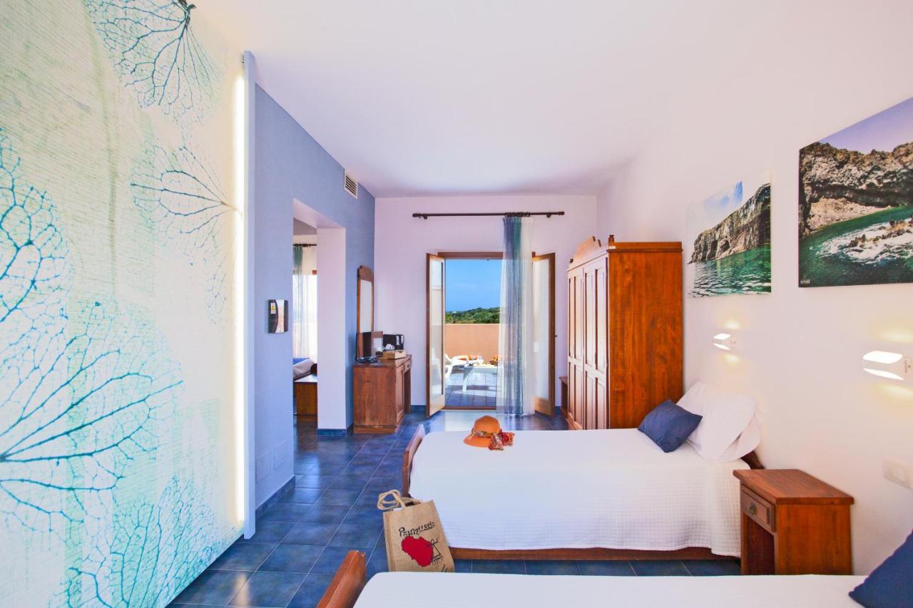 een slaapkamer met een wit bed waarop een hond zit bij Qalea Pantelleria in Pantelleria