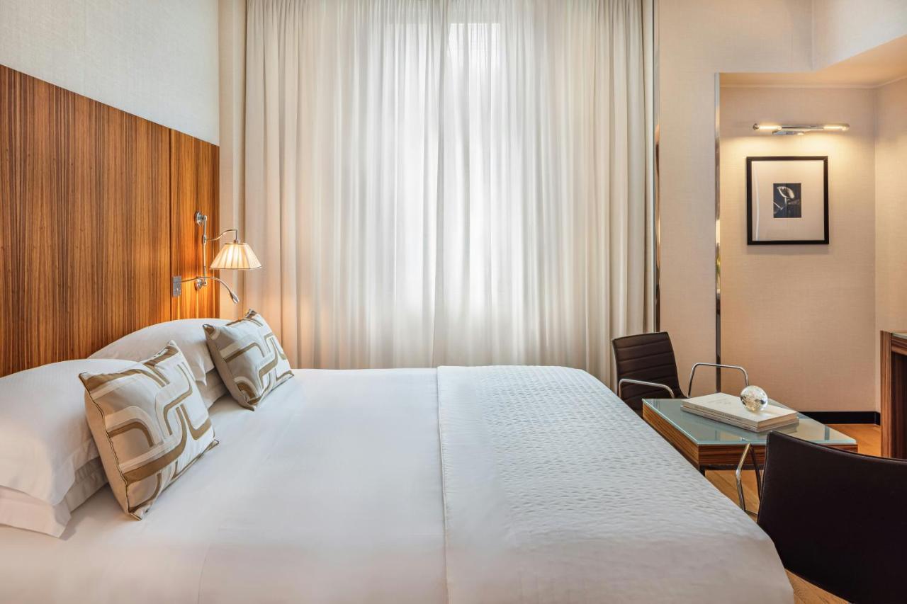 een hotelkamer met een groot wit bed en een bureau bij Starhotels Anderson in Milaan