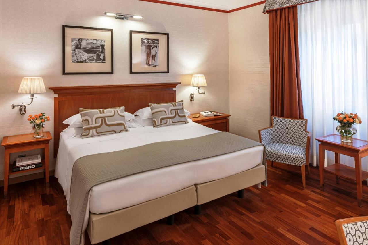 een hotelkamer met een bed en een stoel bij Starhotels Metropole in Rome