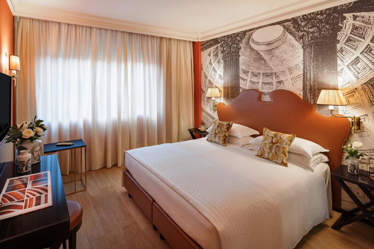 een hotelkamer met een groot bed en een televisie bij Starhotels Michelangelo Rome in Rome