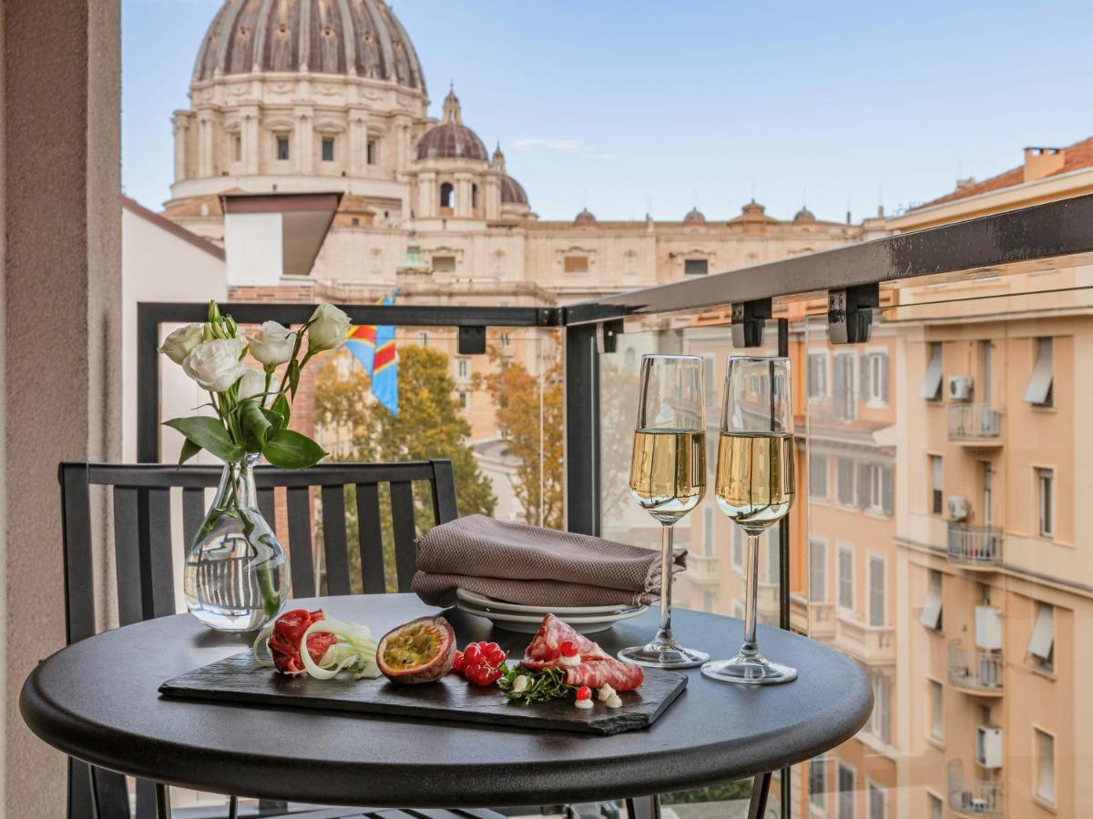 een tafel met twee glazen wijn op een balkon bij Starhotels Michelangelo Rome in Rome