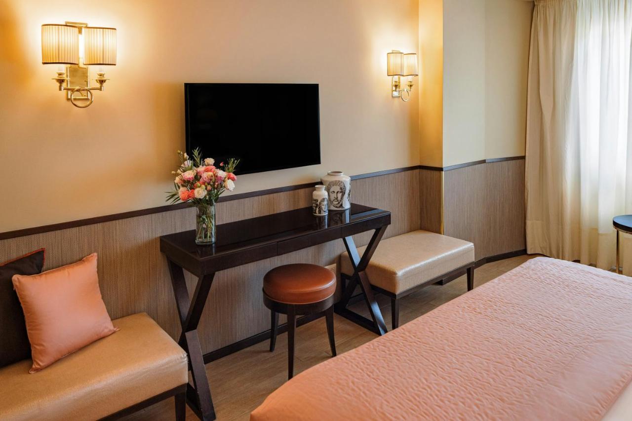een hotelkamer met een bureau en een tv bij Starhotels Michelangelo Rome in Rome