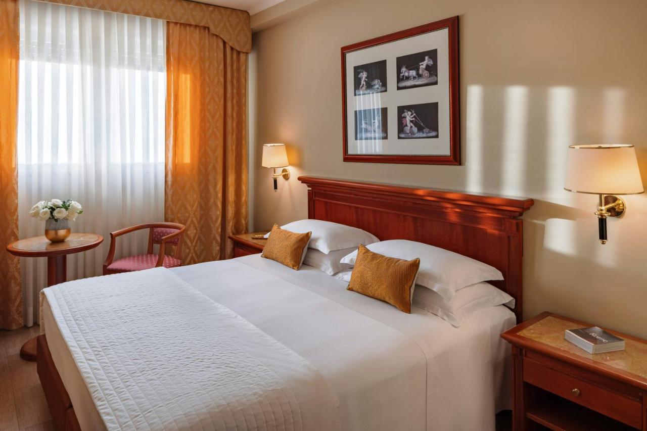 een hotelkamer met een groot bed en een raam bij Starhotels Michelangelo Rome in Rome