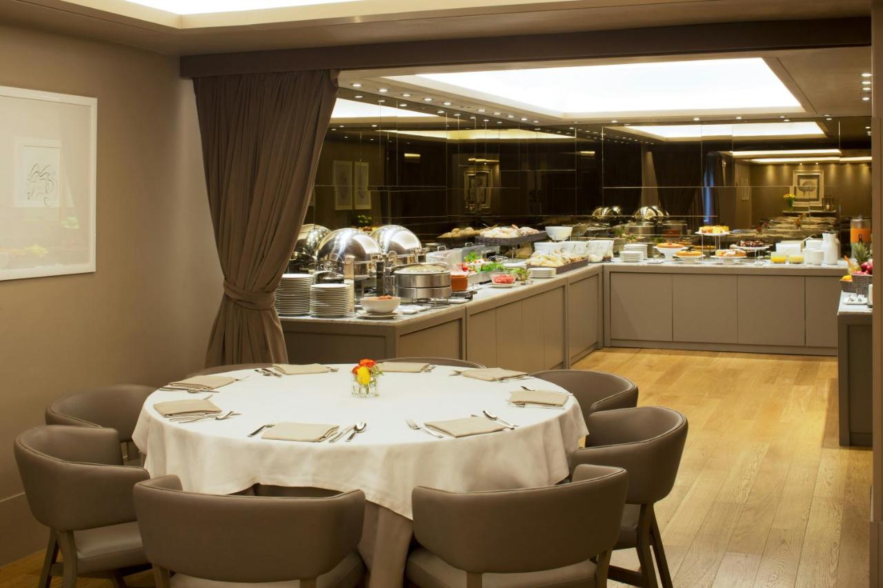 een eetkamer met een tafel en stoelen en een keuken bij Starhotels Michelangelo Florence in Florence