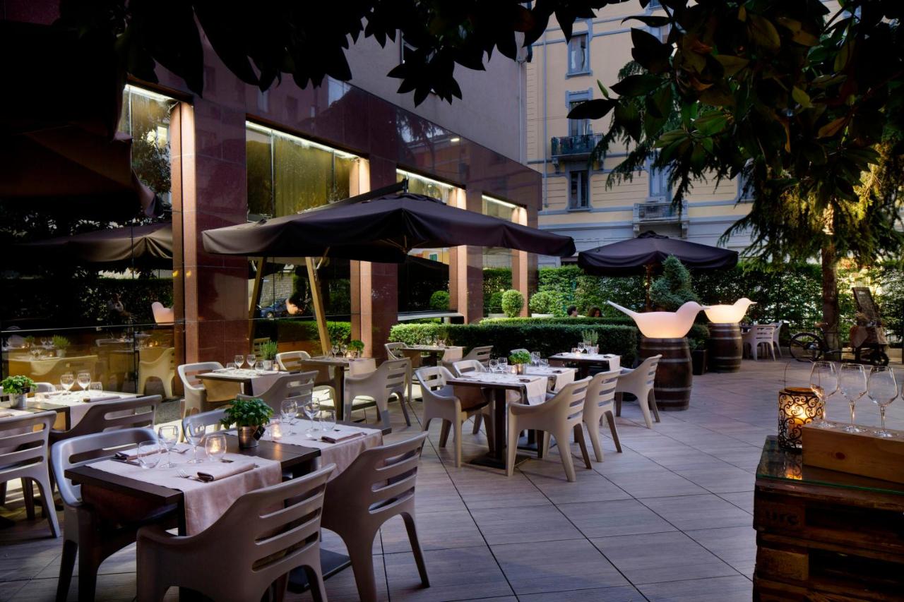 een buitenrestaurant met tafels, stoelen en parasols bij Starhotels Ritz in Milaan