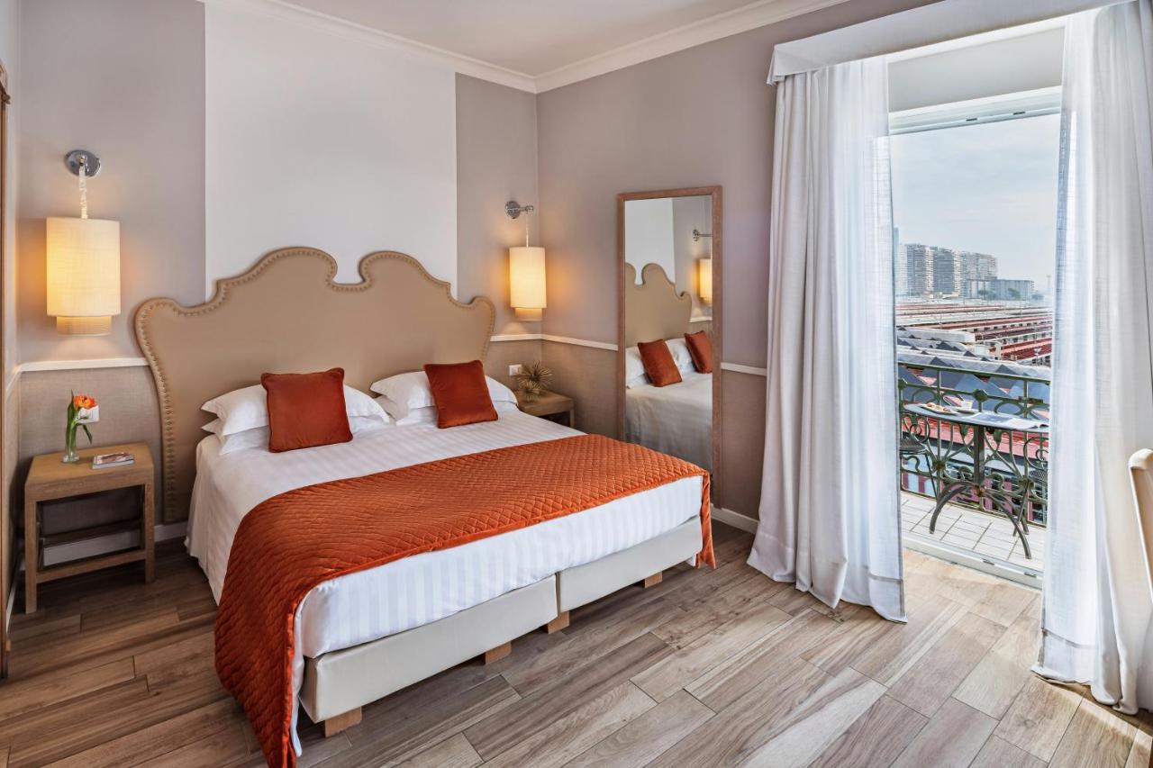 een hotelkamer met een bed en een balkon bij Starhotels Terminus in Napels
